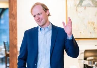 Austin Gurley, Founder CEO speaking in a blue suit.